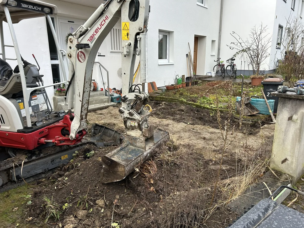 Minibagger bei Baggerarbeiten im Vorgarten – Erdmaterial wird bewegt, Maschineneinsatz in engem Grundstück