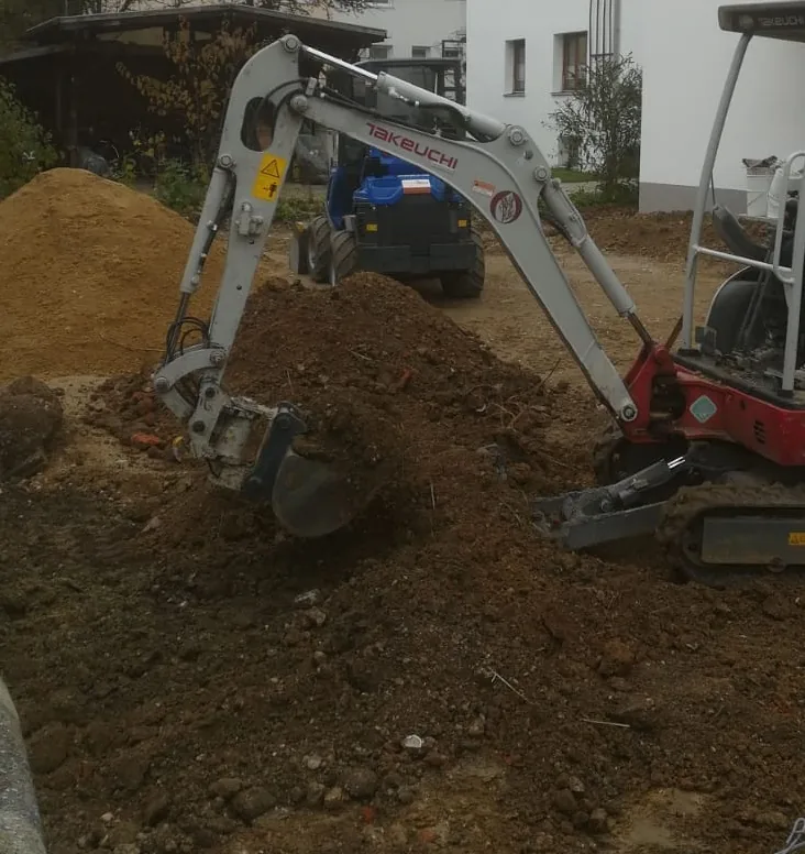 Bagger beim Verladen von Aushubmaterial auf Transporter – Bodenentsorgung als eigenständiger Schritt nach dem Aushub