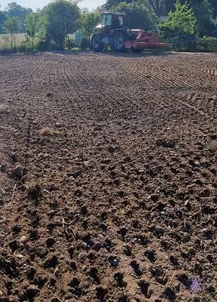 Traktor beim Planieren einer Fläche aus der Vogelperspektive – Gesamtansicht der einzuebnenden Fläche