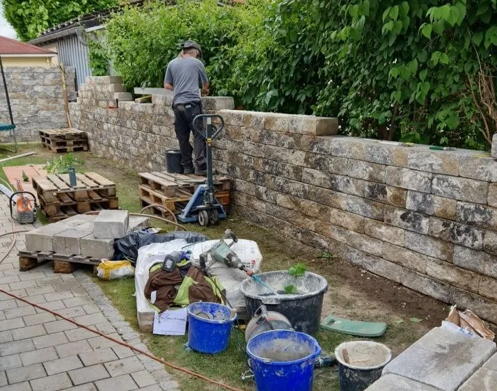 Gartenmauer aus nuanciertem Muschelkalk-Betonstein – fertig gemauerte Anlage mit gleichmäßigem Fugenbild