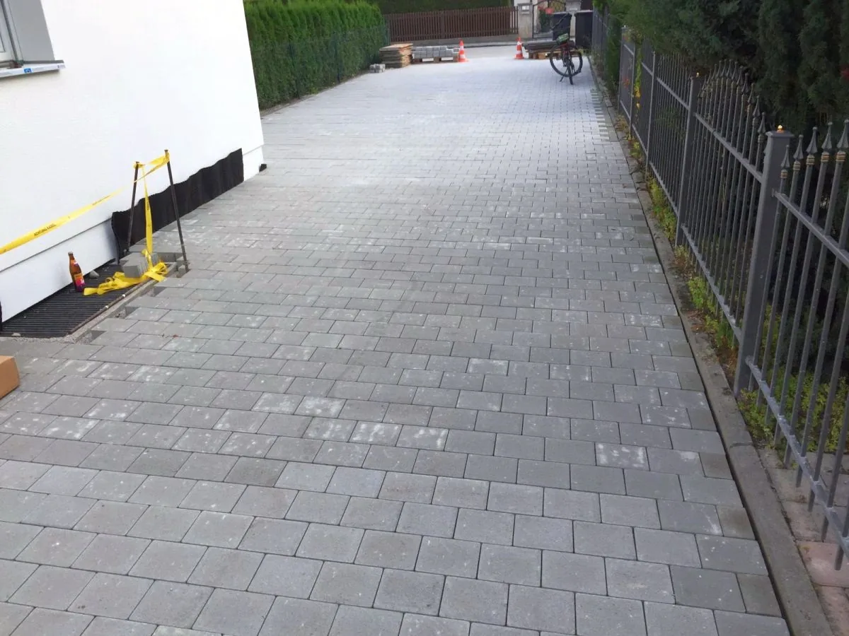 Fertig gepflasterte Einfahrt mit neuem Betonpflaster – Randsteine gesetzt, Fläche eben und entwässert