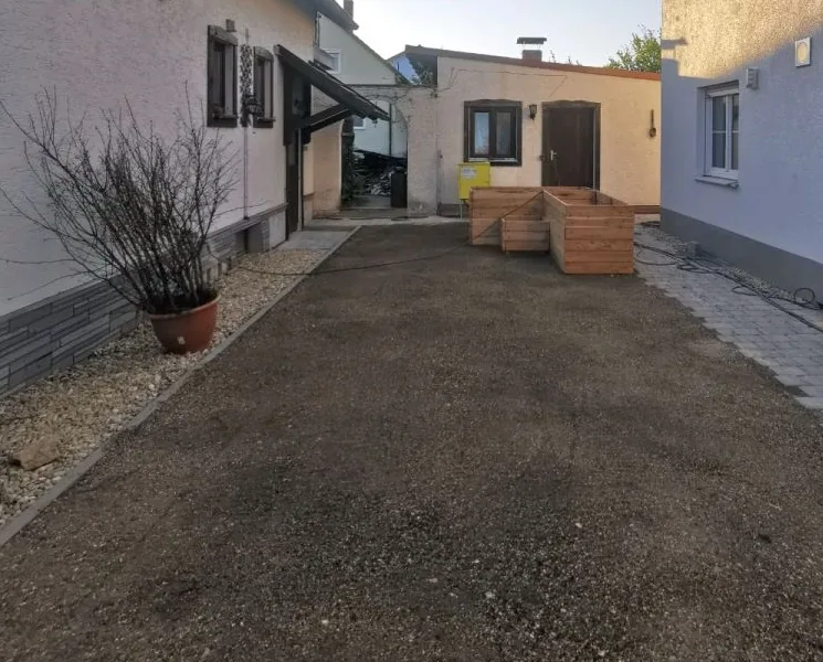 Planierte Rasenfläche vor der Anlage – gleichmäßige Bodenoberfläche mit leichtem Gefälle, bereit für Rollrasen oder Aussaat